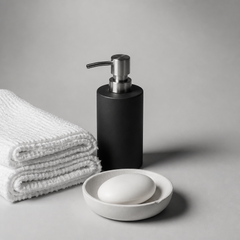 Dispensador de jabon negro mate junto a toallas blancas