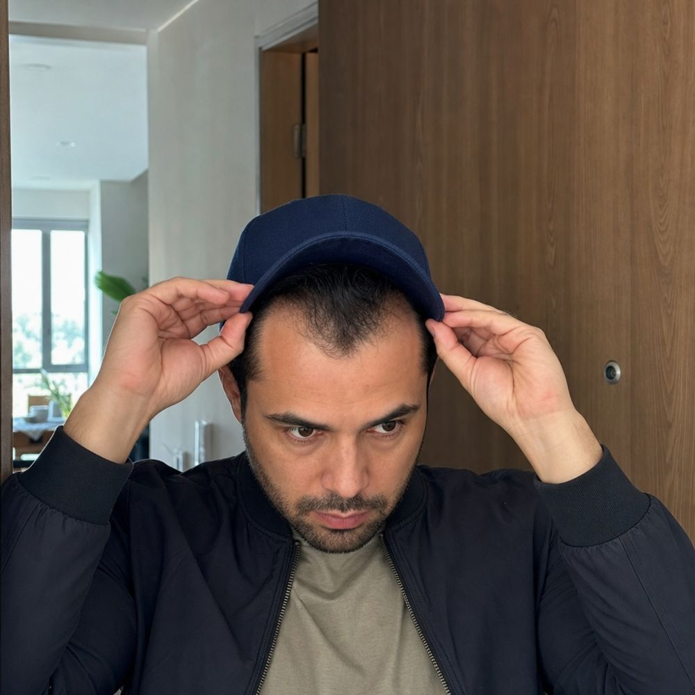 Hombre poniéndose una gorra antes de salir