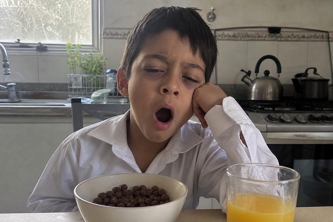 Niño cansado en el desayuno